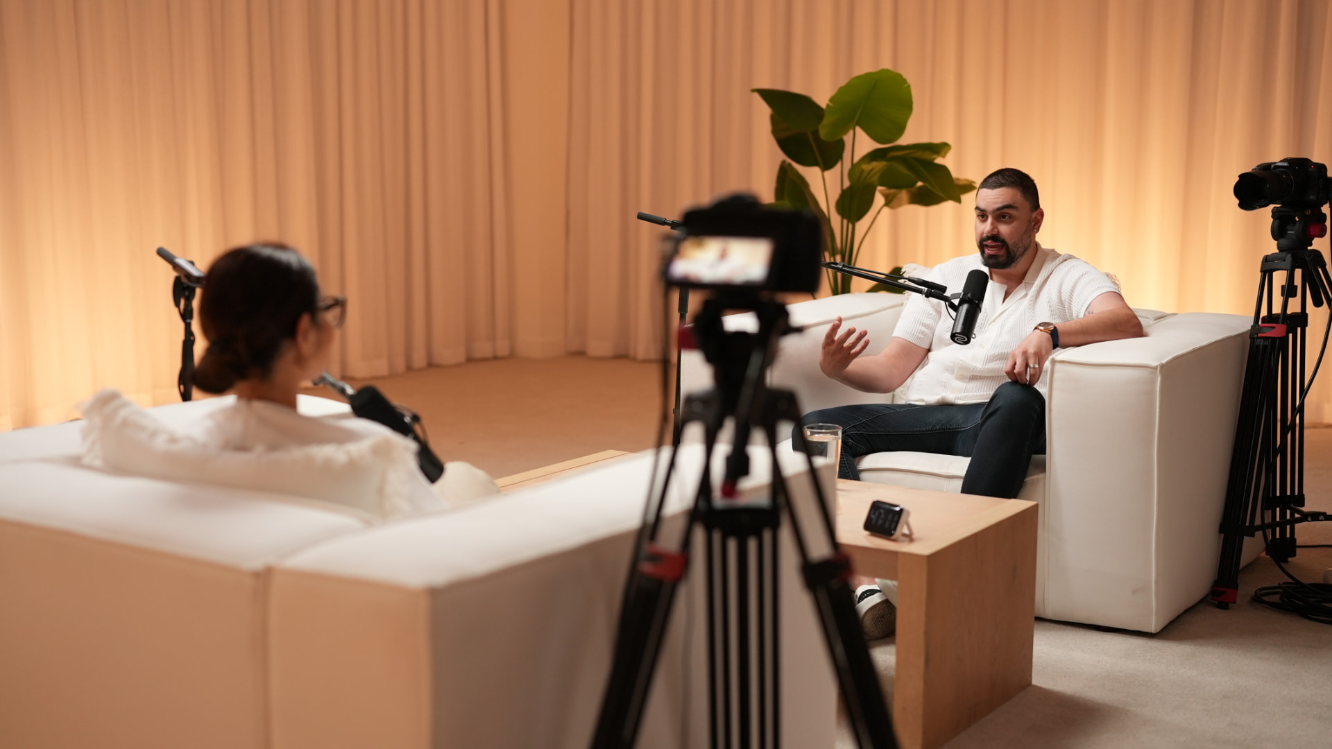 Two camera interview set with cream curtains and warm backlighting